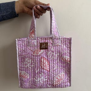 Lavender hand block printed quilted mini tote bag with purple striped trim and soft padded cotton handles.