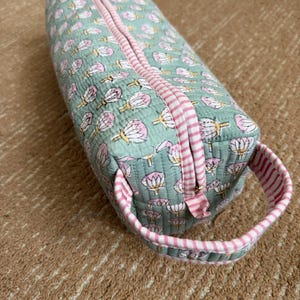 Sage green hand block printed quilted Dyson Airwrap case with pink striped trim, premium YKK zipper, and sturdy carry handle for travel and storage.