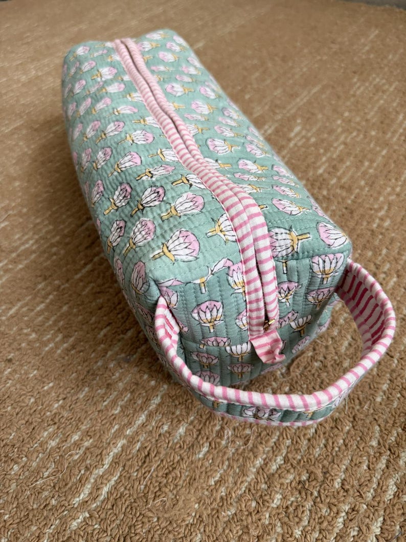 Sage green hand block printed quilted Dyson Airwrap case with pink striped trim, premium YKK zipper, and sturdy carry handle for travel and storage.