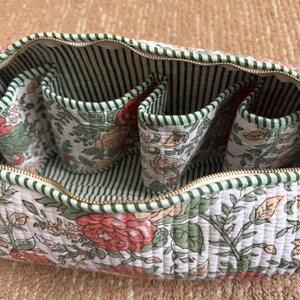 Hand block printed quilted Dyson Airwrap organizer with four padded interior pockets, green striped lining, and premium YKK zipper for secure storage.