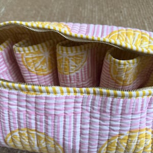 Pink quilted organizer for Dyson Airwrap, curling barrels, and hair accessories.