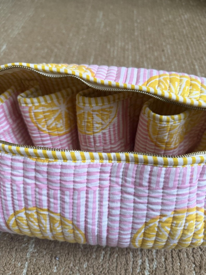 Pink quilted organizer for Dyson Airwrap, curling barrels, and hair accessories.