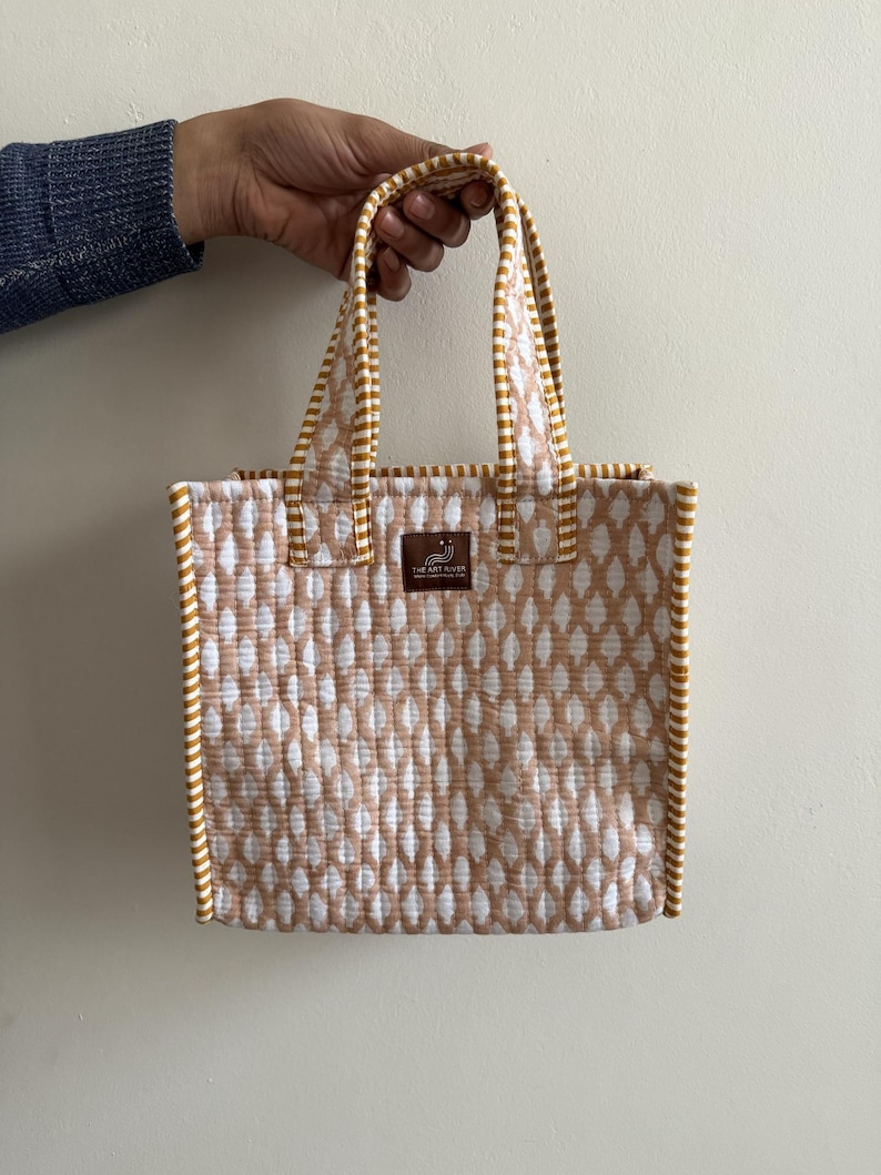 Beige block printed quilted mini tote bag with mustard striped trim, reusable cotton lunch bag with handles.