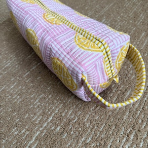 Quilted cotton pink lemon print hair tool organizer with yellow striped trim.
