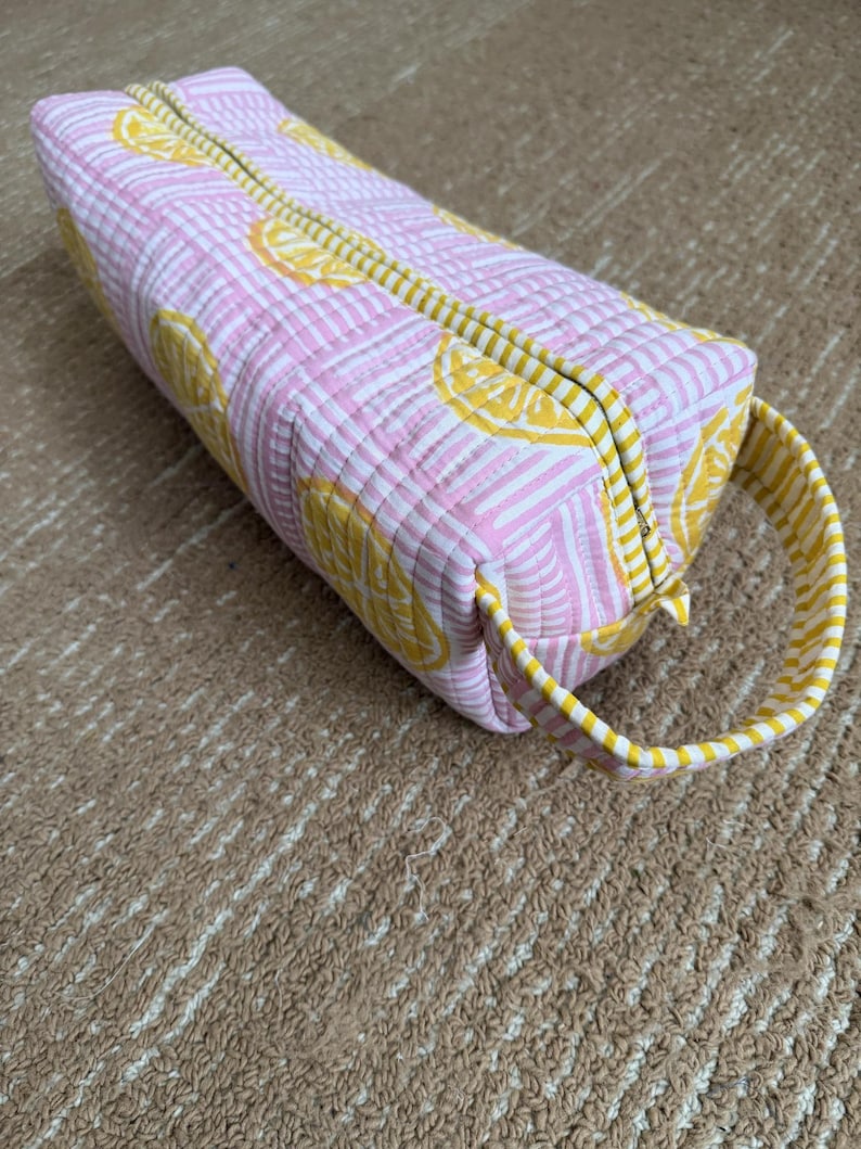 Quilted cotton pink lemon print hair tool organizer with yellow striped trim.