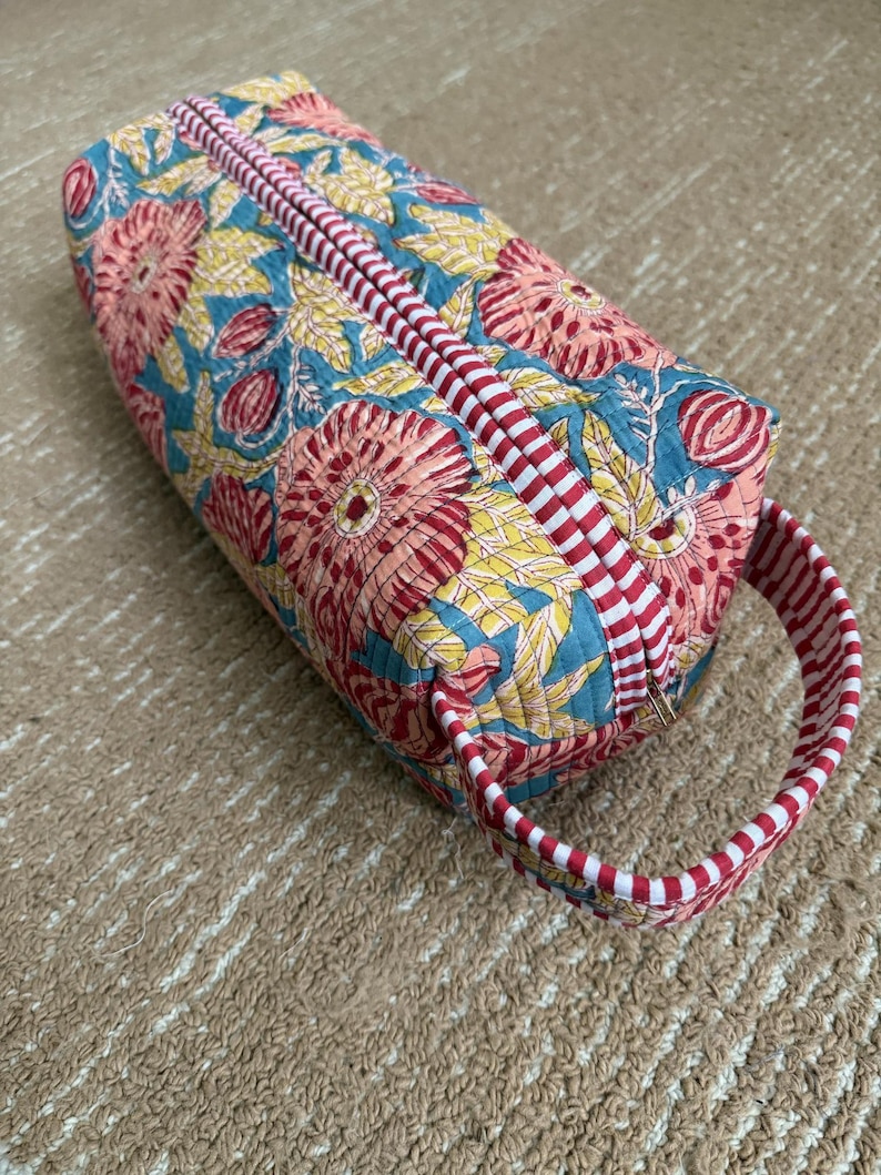 Handmade floral hair styling case with padded compartments and zipper closure.