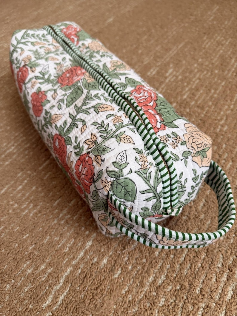 Quilted cotton floral hair tool organizer with green striped trim and carry handle.