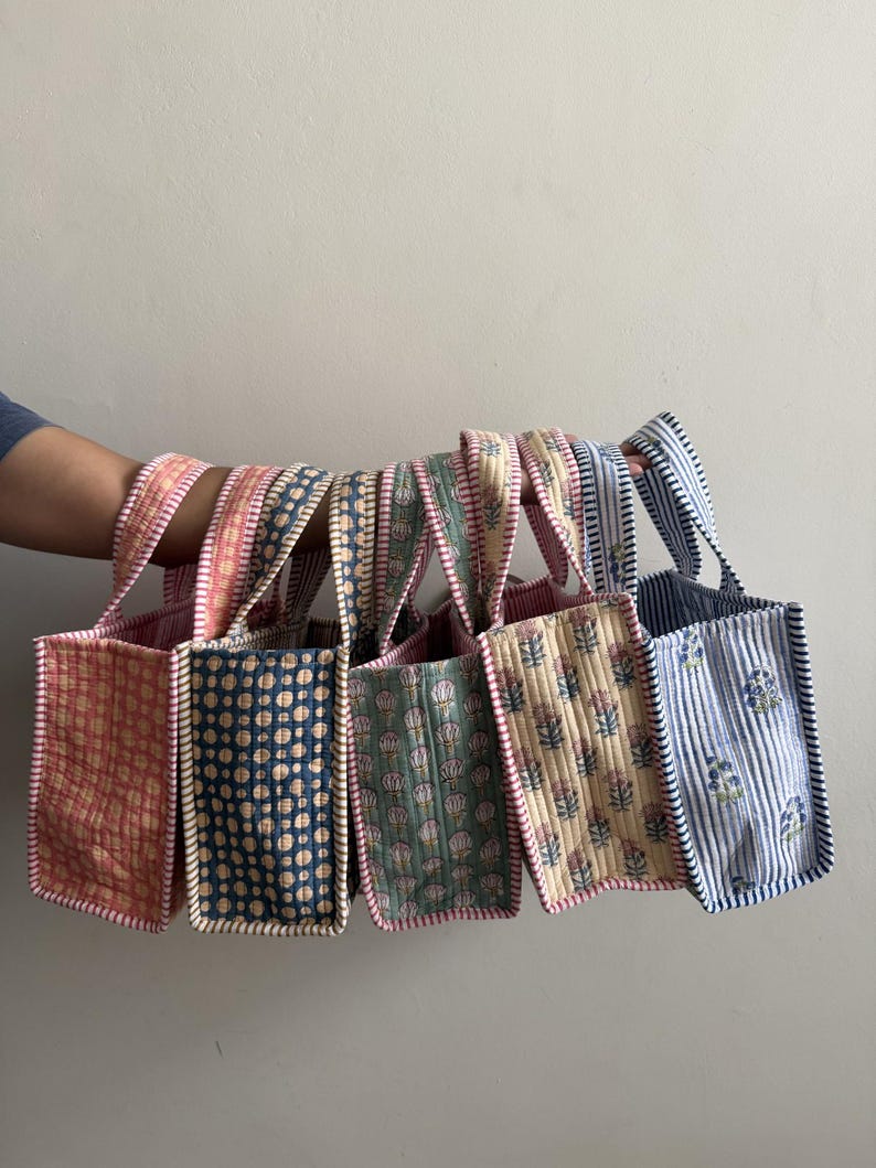 Assorted handmade quilted cotton mini tote bags featuring floral and botanical hand block prints in multiple colors, displayed together to showcase the collection.