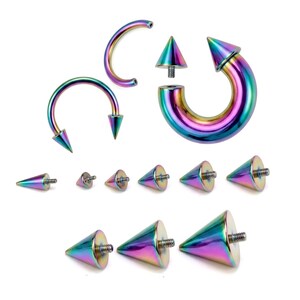 May include: A collection of iridescent body jewelry, including curved barbells, circular barbells, and replacement cone-shaped spikes. The jewelry has a metallic finish with a rainbow color effect, reflecting various hues.