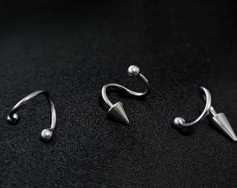 May include: Three silver spiral earrings with a ball on one end and a pointed tip on the other end.