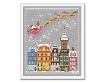 May include: A cross-stitch pattern featuring a winter scene with Santa Claus flying over a town with colorful houses and a clock tower. The sky is gray with snowflakes and the text "ho ho ho" is written in the sky.