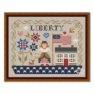 Op de afbeelding: Borduurpatroon met een vrouw in een rood-wit-blauwe jurk die een mandje vasthoudt, een huis met een rode deur, een vlag en het woord "LIBERTY" in een bruin frame.