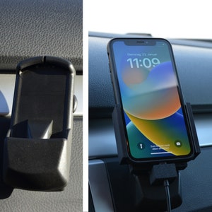 Könnte beinhalten: Ein schwarzer Handyhalter für ein Auto-Armaturenbrett. Der Halter verfügt über einen federbelasteten Mechanismus, um das Handy zu sichern. Das Handy befindet sich in einer schwarzen Hülle und hat einen hellen, bunten Bildschirm. Das Handy zeigt die Uhrzeit 11:09 an.