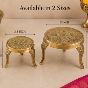 May include: Two round brass stands with engraved floral patterns and curved legs. The smaller stand measures 3.5 inches in diameter and 3 inches in height. The larger stand measures 5 inches in diameter and 4 inches in height. Text reads Available in 2 Sizes.