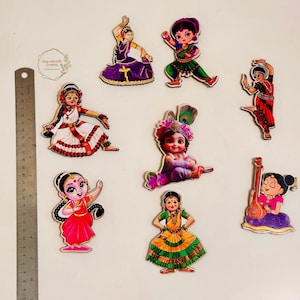 May include: Set of eight colorful wooden figurines depicting Indian dancers and deities. The figurines are painted with intricate details and feature traditional Indian clothing and accessories.