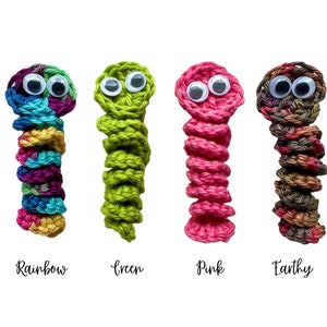 Puede incluir: Cuatro juguetes de gusano de crochet con ojos saltones. Los gusanos son de colores arco&iacute;ris, verde, rosa y tierra.