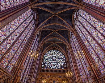 May include: A view of the interior of a chapel with stained glass windows and a vaulted ceiling. The windows are made of colorful glass and depict religious scenes. The ceiling is decorated with intricate patterns.