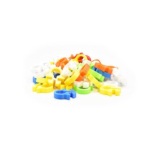 May include: A pile of colorful plastic toy rings in various colors, including yellow, blue, orange, green, and white. The rings are in different shapes and sizes, suggesting a building toy or educational game.