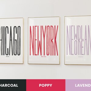 Puede incluir: Tres impresiones enmarcadas con los nombres de ciudades en letras en negrita y estilizadas. Las impresiones son en carb&oacute;n vegetal, rojo amapola y lavanda. Las ciudades son Chicago, Nueva York y Nueva Orleans.