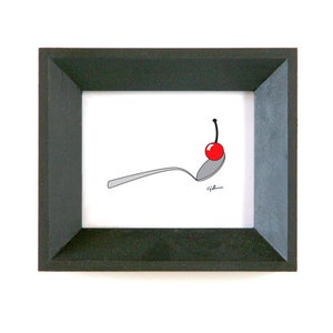 May include: A framed black and white illustration of a spoon with a red cherry on top. The spoon is lying on its side and the cherry is balanced on the spoon's bowl. The illustration is signed "Gil".