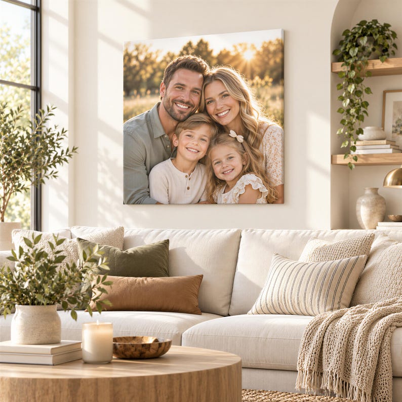 A family portrait of a man, woman, and two children is displayed on the wall above a beige sofa in a cozy living room setting.
