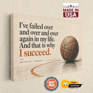 Könnte beinhalten: Ein rechteckiges Leinwandbild mit einem Basketball auf einem Spielfeld und dem Zitat: I've failed over and over and over again in my life. And that is why I succeed. Michael Jordan. Der Hintergrund ist in einem hellen Cremeton gehalten.