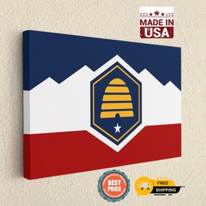May include: A rectangular canvas print featuring the Utah state flag design with horizontal stripes of blue, white, and red. A central hexagon contains a yellow beehive icon above a white star. The text MADE IN USA appears in the top right corner.