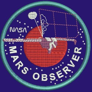 May include: A blue and white embroidered patch with the text "NASA MARS OBSERVER" and a stylized image of a spacecraft orbiting a red planet.
