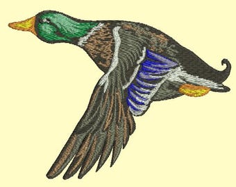 May include: An embroidered image of a duck in flight, featuring a green head, brown and black body, and blue and white wing details. The duck's beak is orange, and the wings are spread wide.