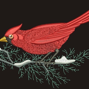 May include: Embroidered image of a vibrant red cardinal bird perched on a snow-covered branch with green needles. The bird has a yellow beak and is set against a black background. The embroidery details are intricate.