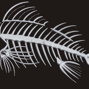 Op de afbeelding: Wit geborduurd visskeletontwerp op een zwarte achtergrond. De gedetailleerde borduursels tonen de botstructuur van een vis, inclusief schedel, ribben en staartvin. Geschikt voor kleding en accessoires.