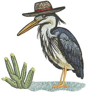 May include: Embroidered design of a blue heron wearing a brown hat with a red band. The bird has a long yellow beak and stands near green plants. The design is on a light blue surface, with detailed stitching.