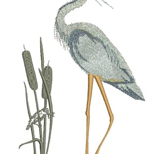 May include: An embroidered design of a Great Blue Heron standing near cattails. The bird has light blue and gray feathers, long orange legs, and a long beak. The cattails are green and brown.