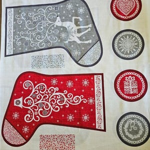 May include: Red and gray Christmas stocking fabric with a white background. The stockings feature a stylized Christmas tree and a reindeer with ornaments. The fabric also includes decorative circles with a heart, snowflake, gift, and wreath.