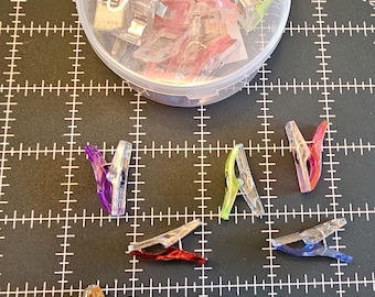 Suministros para telas - Clips para ribetear edredones Annies con contenedor mediano. Permite sujetar varias capas de tela, etc. *Precio: 11,99/paquete. Cantidad: 50/contenedor mediano.