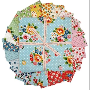 May include: A collection of floral fabric squares in various colors, including blue, pink, yellow, and green. The fabric features rose and dot patterns. A ribbon with the text "Poppie Cotton sunshine and joy in every detail" is tied around the center.