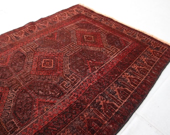 May include: A red and black patterned rug with a geometric design. The rug has a fringe border.