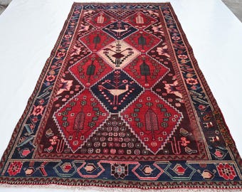 Puede incluir: Una alfombra persa tradicional con un patrón geométrico rojo, azul y blanco. La alfombra presenta pájaros estilizados y motivos florales.