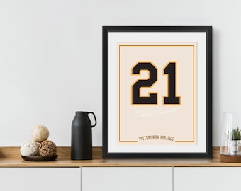 May include: A framed print with a black and gold number 21 on a peach background. The text "Pittsburgh Pirates" is below the number.