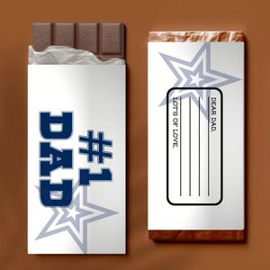 Op de afbeelding: Een chocoladereep met een witte verpakking met de tekst "DAD #1" in blauw. De verpakking bevat ook een sterontwerp. De andere kant van de verpakking heeft de tekst "DEAR DAD" en "LOTS OF LOVE" met lijnen om op te schrijven.