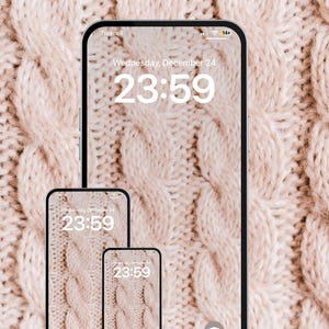 Op de afbeelding: Drie smartphones met een kabelgebreid patroon als achtergrond. De tijd is 23:59 uur op woensdag 24 december. De achtergrond is een close-up van een lichtbeige kabelgebreide stof.