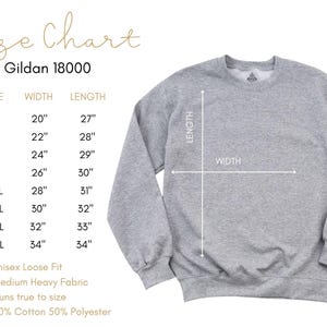 K&ouml;nnte beinhalten: Hellgraues Gildan 18000 Sweatshirt mit Gr&ouml;&szlig;entabelle. Die Tabelle listet die Gr&ouml;&szlig;en S bis 5XL mit entsprechenden Breiten- und L&auml;ngenma&szlig;en in Zoll. Das Sweatshirt ist unisex, locker geschnitten, aus mittelschwerem Stoff und f&auml;llt gr&ouml;&szlig;engetreu aus.