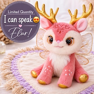 Puede incluir: Un peluche de ciervo con pelaje rosa, pecho color crema y astas doradas. Tiene grandes ojos marrones, alas translúcidas con filigrana dorada y patas doradas. Un gráfico circular morado incluye el texto: Limited Quantity I can speak Elur!