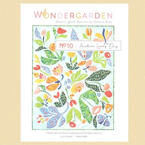 May include: A quilt pattern design titled "Another Lonely Day" from the Wondergarden collection by Tamara Kate. The pattern features a colourful floral design with butterflies and leaves on a light blue background.