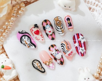 May include: A collection of whimsical nail art designs featuring Alice in Wonderland themes. Designs include a melting clock, playing cards, a key, a keyhole, and a rabbit. Some nails have the words "DRINK ME" and "EAT ME".