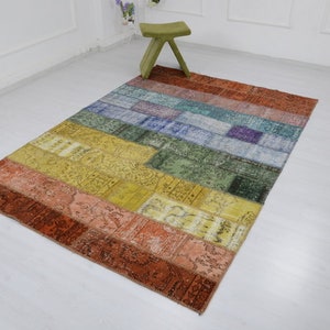 以下が含まれることがあります： 赤、オレンジ、黄色、緑、青、紫など、さまざまな色とパターンが組み合わされたカラフルなパッチワークラグです。