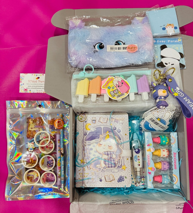 Op de afbeelding: Een briefpapier-cadeauset met een pluizig pastelkleurig etui, een notitieboek met een eenhoornthema, gummen in de vorm van ijsjes, een panda-notitieblok, een sleutelhanger, rollen washi-tape, decoratieve stickers en kleurrijke pennen.