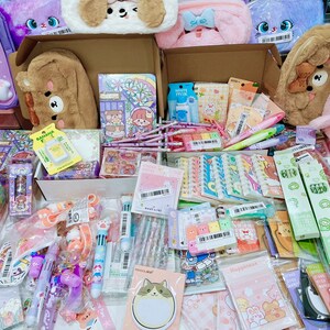 Puede incluir: Una colecci&oacute;n de art&iacute;culos de papeler&iacute;a coloridos, que incluyen bol&iacute;grafos, l&aacute;pices, pegatinas y blocs de notas. Los art&iacute;culos est&aacute;n dispuestos en una variedad de cajas y bolsas, y algunos est&aacute;n decorados con personajes de animales lindos. Los art&iacute;culos son todos nuevos y sin usar.