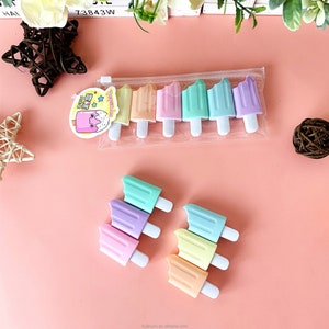 May include: Six pastel-colored popsicle shaped highlighters in a clear plastic bag. The highlighters are arranged in a row with the tips facing the viewer. The highlighters are in the colors purple, pink, yellow, light blue, green, and blue.