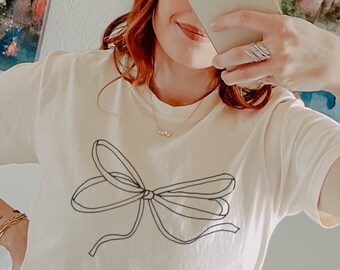 Lindo diseño de lazo Camiseta de colores cómodos Camisa casual elegante con lazo Camiseta gráfica Camiseta con lazo para mujer Diseño de lazo cómodo Cuello redondo Camisa con lazo elegante